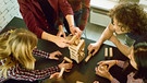 Freunde spielen gemeinsam ein Turmspiel. Viele Brettspiele wie Schach, "Mensch ärgere dich nicht" und Mühle sind mehrere jahrhundertealt. | Bild: colourbox.com