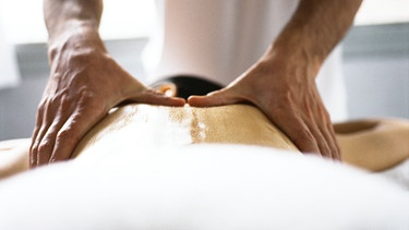 Bei Rückenschmerzen können auch alternative Therapien helfen - Akkupunktur. Massage (wie hier im Bild Hände auf Rücken), Krankengymnastik, Yoga, Osteopathie, Chiro, Rolfing, Shiatsu - vieles kann Linderung der Rückenschmerzen verschaffen | Bild: colourbox.com
