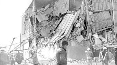 Zerstörtes Gebäude nach dem Erdbeben in Alaska 1964.  Starke seismische Aktivitäten und Verschiebungen tektonischer Platten können riesige Flutwellen, japanisch: Tsunamis auslösen. | Bild: picture-alliance/dpa