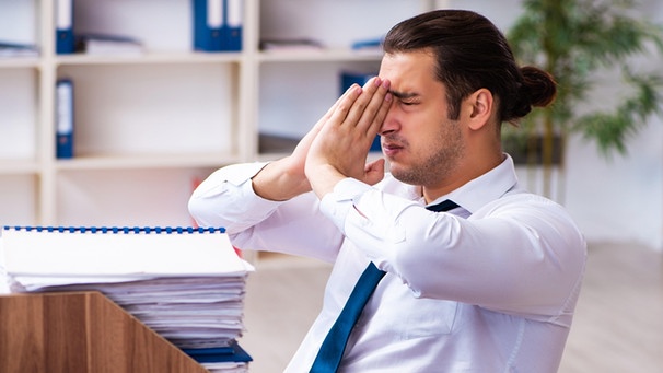 Überforderter und gestresster Mitarbeiter am Schreibtisch | Bild: picture-alliance/ Zoonar|Elnur Amikishiyev