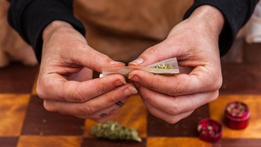 Ein Cannabis-Konsument hält dreht sich einen Joint. | Bild: picture-alliance/dpa