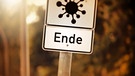 Schild mit Coronavirus-Symbol und Schild mit Aufschrift Ende, | Bild: picture alliance / CHROMORANGE | Christian Ohde