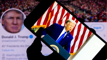 Rede von Donald Trump, Präsident der Vereinigten Staaten, auf dem Smartphone. Im Hintergrund Trumps offizielle Twitter-Seite. | Bild: picture alliance / Zoonar | Rafael Henrique | F O T O G R A F I A