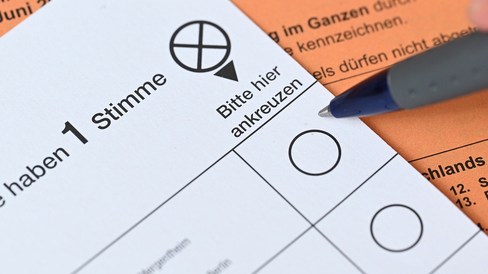 Europawahl 2024: Ein Wahlzettel für die Wahl zum Europaparlament liegt auf einem Tisch, dahinter der Stimmzettel für die Wahl der Vertreter der Regionalversammlung. | Bild: picture alliance/dpa | Bernd Weißbrod