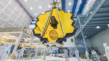 Dieses von der NASA zur Verfügung gestellte Foto zeigt Techniker, die die Spiegelbaugruppe des James Webb-Teleskops im Goddard Space Flight Center der NASA anheben.  | Bild: dpa-Bildfunk/Uncredited