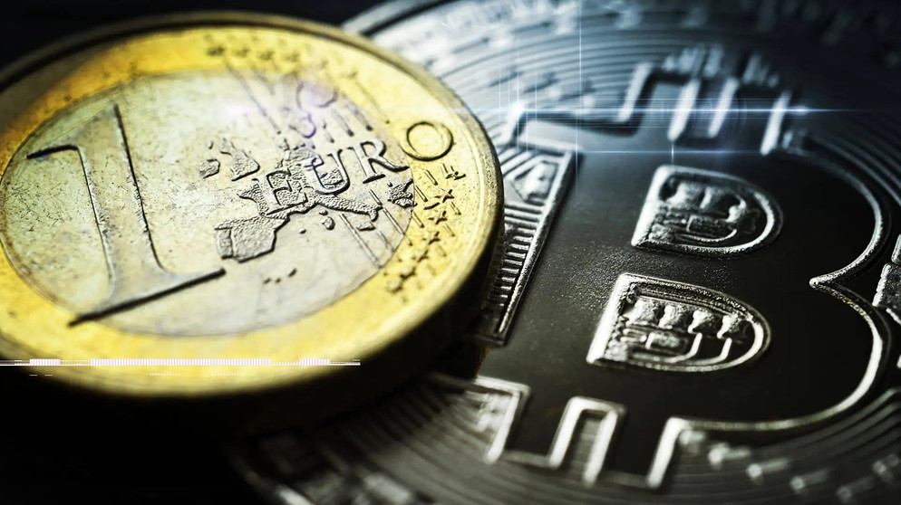 Ein-Euro-Münze liegt auf Bitcoin-Münze. | Bild: Imago Images