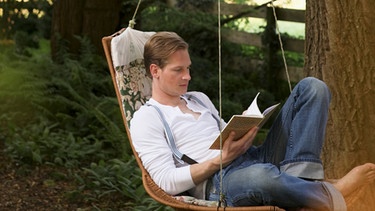 Ein Mann sitzt in einer Hängematte und liest ein Buch. Wir erklären euch, wie achtsames Lernen und Üben funktionieren kann.  | Bild: colourbox.com