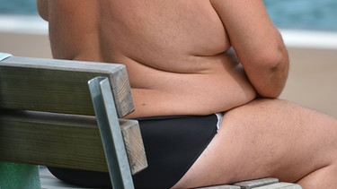 Übergewichtiger Mensch sitzt auf einer Bank | Bild: picture-alliance / dpa / Franziska Kraufmann