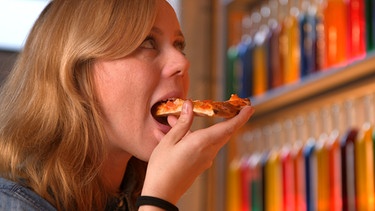Moderatorin beißt in Pizzastück | Bild: BR