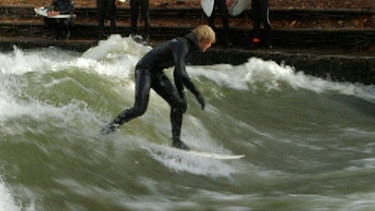 Ein Surfer fährt eine Welle entlang | Bild: BR