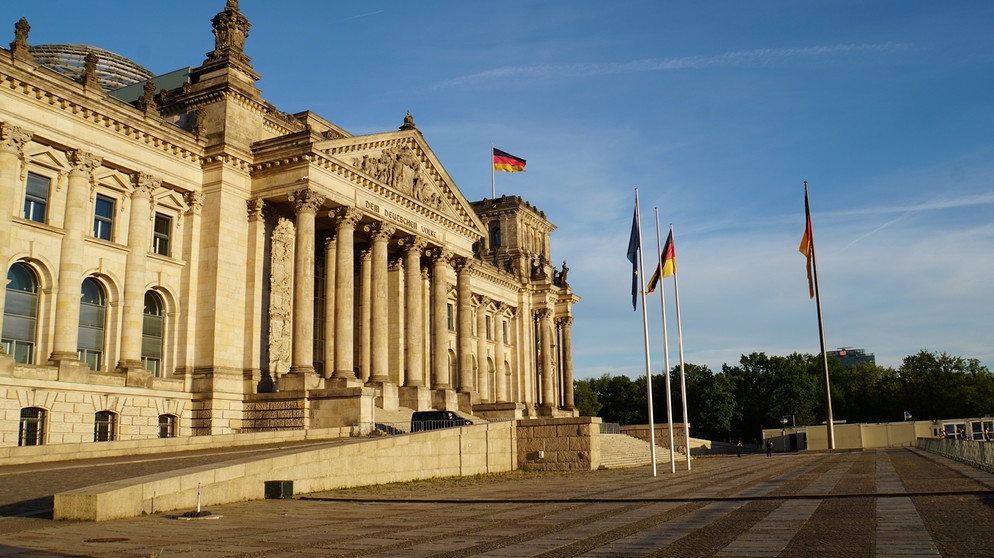 Westansicht des Reichstagsgebäudes in Berlin in der Abendsonne mit Europaflagge und Deutschlandflagge. | Bild: BR/Nicole Voigtländer