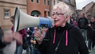 Frau mit Megaphon auf einer Querdenker-Demonstration. | Bild: rbb
