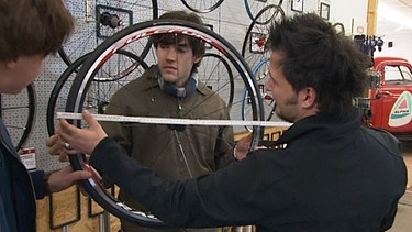 Lehrer zeigt an einem Fahrradreifen den Durchmesser | Bild: BR