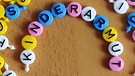 Das Wort Kinderarmut aus Spielsteinen gelegt | Bild: picture-alliance/dpa