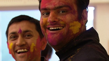 Teilnehmer bemalen sich mit Farben bei der Vorbereitung für das Holi-Fest. | Bild: BR