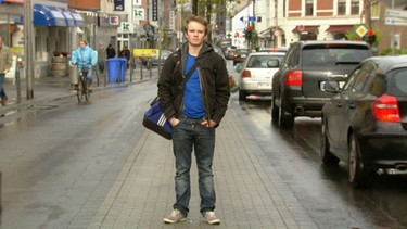 Christian blickt in die Kamera, stehend auf der Straße | Bild: BR