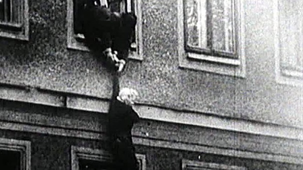 Eine Frau wird an einem Grenzhaus in Berlin heruntergelassen | Bild: BR
