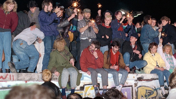 Menschen feiern auf der westdeutschen Seite der Berliner Mauer die Grenzöffnung | Bild: picture-alliance/dpa
