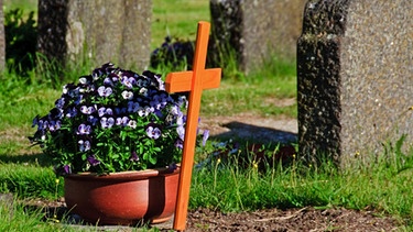 Gräber auf dem Friedhof mit einem Blumengesteck | Bild: colourbox.com