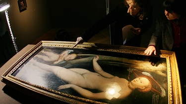 Expertinnen untersuchen das Bild "Venus und Amor als Honigdieb" von Lucas Cranach dem Älteren. | Bild: picture-alliance/dpa/Boris Roessler