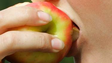 Ein Mensch beißt herzhaft in einen Apfel | Bild: colourbox.com