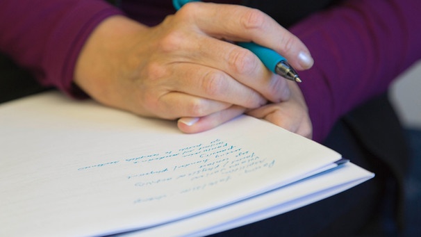 Hand nah mit Stift hält einen Schreibblock  | Bild: picture-alliance/dpa