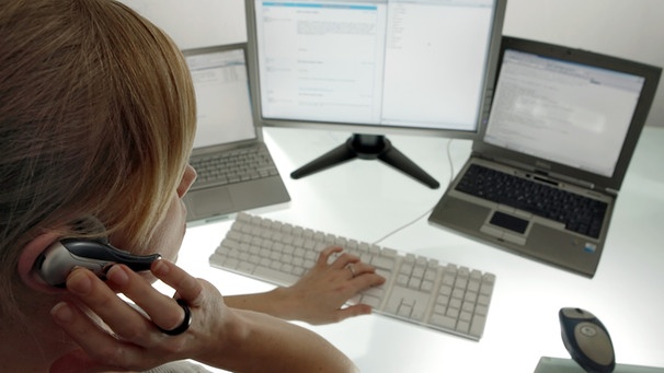 Frau vor drei Monitore, tippt auf Tastatur | Bild: picture-alliance/dpa