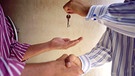 Makler übergibt Hausschlüssel an einen Käufer | Bild: Image Source