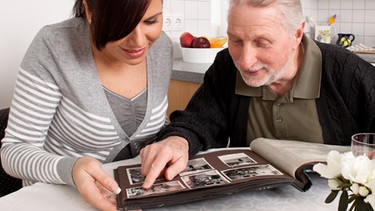 alter Mann betrachtet mit seiner Enkelin ein altes Fotoalbum | Bild: colourbox.com