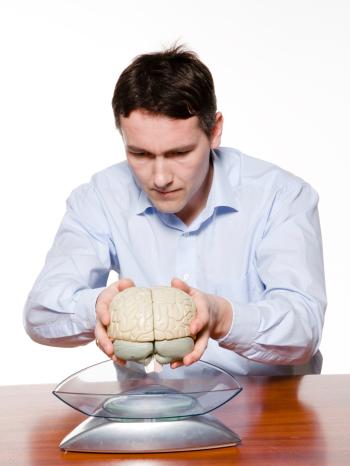Ein Mann wiegt ein menschliches Gehirn | Bild: colourbox.com