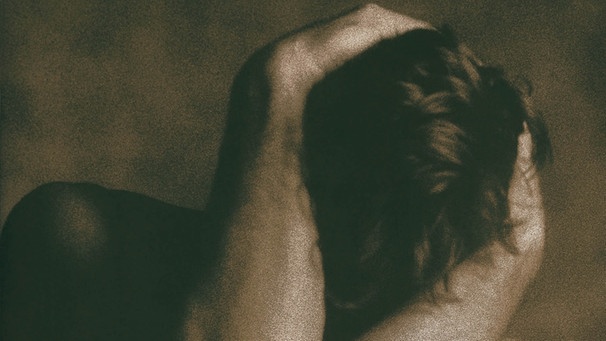 Nackter Mann bedeckt seinen Kopf mit den Armen | Bild: Image Source