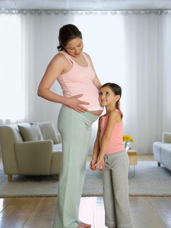 Mädchen horcht am Bauch der schwangeren Mutter | Bild: Image Source