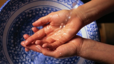 Hände waschen über einer Schüssel | Bild: Getty Images