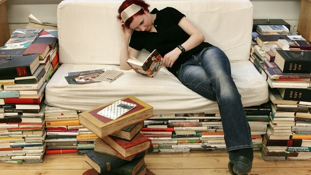 Frau liest auf einem "Büchersofa" | Bild: picture-alliance/dpa
