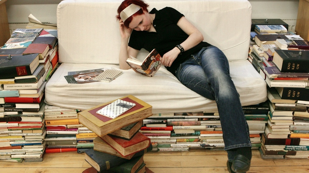 Frau liest auf einem "Büchersofa" | Bild: picture-alliance/dpa