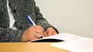 Frau macht Notizen auf einem Blatt Papier | Bild: picture-alliance/dpa