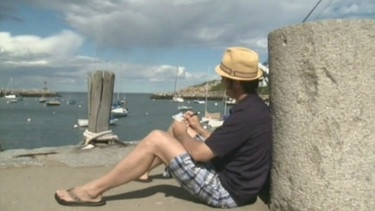 Eric sitzt am Hafen und blickt aufs Meer | Bild: BR