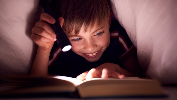 Eine wichtige Voraussetzung, um Frreude an Büchern zu haben, ist es, das Lesen zu trainieren. Am besten in der Schule. Erst danach stellt sich überhaupt die Frage: Was kann Kinder motivieren, mehr zu lesen? | Bild: picture alliance / Shotshop | Monkey Business 2