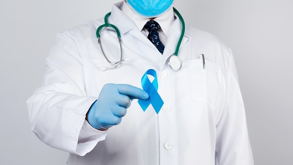 Ein Urologe hält ein blaues Band als Symbol für die Prostatakrebsvorsorge | Bild: picture-alliance/Zoonar|Danko Natalya