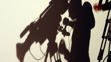 Schatten eines Fernsehkameramanns. | Bild: picture-alliance