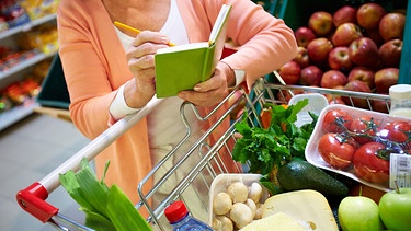 Frau mit Notizbuch beim Lebensmittel-Einkauf | Bild: colourbox.com/Pressmaster