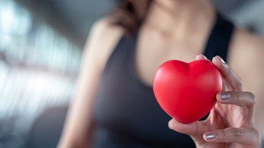 Um das Gehirn gesund zu halten, sind Bewegung und ein gesundes Herz extrem wichtig. Symbolbild: Eine Frau in Sportklamotten hält ein rotes Herz in der Hand. | Bild: colourbox.com