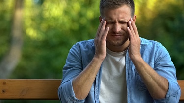 Gestresster Mann auf einer Parkbank. Wie kann man Stress reduzieren? | Bild: colourbox.com