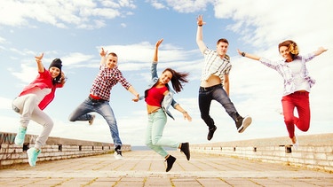 Eine Gruppe junger Menschen tanzt und springt. | Bild: colourbox.com