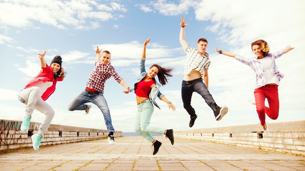 Eine Gruppe junger Menschen tanzt und springt. | Bild: colourbox.com