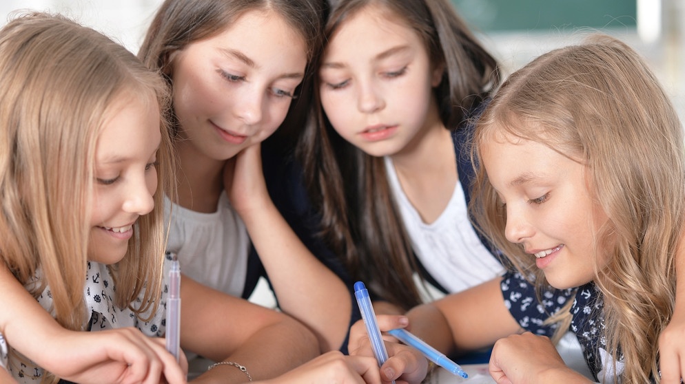 Mehrere Mädchen schreiben etwas auf einen Zettel. Lernen Mädchen besser ohne Jungen? | Bild: colourbox.com