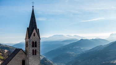 Panoramaufnahme von Villanders mit Kirchturm und Bergkulisse. | Bild: picture alliance / Zoonar | Phil Bird