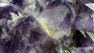 Ein violetter Amethyst, wie hier auf dem Foto, kann bis zu 100 Euro pro Karat kosten. Manche schreiben diesem Mineral heilsame Kräfte zu, z. B. bei Kopfschmerzen.  | Bild: Museum Reich der Kristalle / Mineralogische Staatssammlung, München