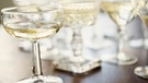 Mehrere Gläser, darunter ein Coupe, sind mit Champagner gefüllt. | Bild: picture-alliance/dpa
