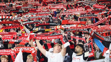 Fußballfans in Feierlaune mit Fanschal  | Bild: picture alliance / johapress | Joachim Hahne